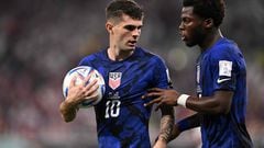 USA's forward #10 Christian Pulisic (L) speaks with USA's midfielder #06 Yunus Musah during the Qatar 2022 World Cup Group B football match between Iran and USA at the Al-Thumama Stadium in Doha on November 29, 2022. (Photo by Fabrice COFFRINI / AFP)