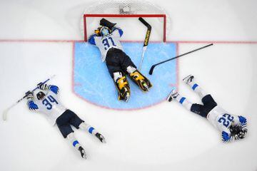 Tres jugadores de Finlandia caen en el hielo tras perder la final ante Canadá. (Photo by Andy Devlin/ Getty Images).