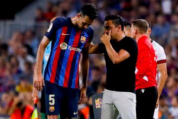 Xavi Hernández and Sergio Busquets chat during a match at camp Nou.