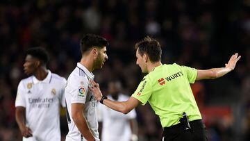 Spanish referee Ricardo De Burgos Bengoetxea (R) talks to Real Madrid's Spanish midfielder Marco Asensio after annulling his goal following a VAR decision during the Spanish league football match between FC Barcelona and Real Madrid CF at the Camp Nou stadium in Barcelona on March 19, 2023. (Photo by Josep LAGO / AFP)