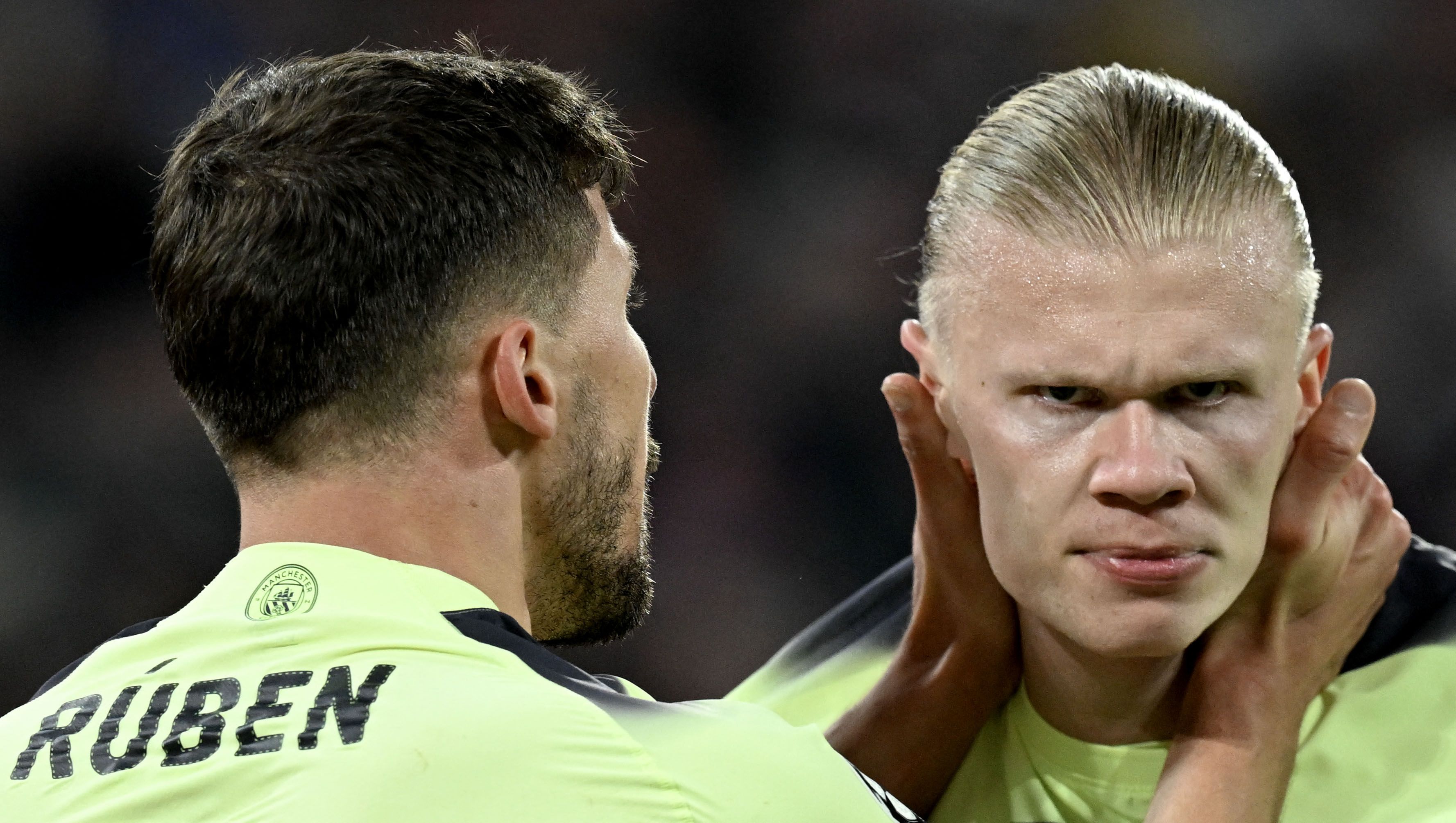 Manchester City's Norwegian striker Erling Haaland (R) is congratulated by Manchester City's Portuguese defender Ruben Dias after scoring the 0-1 opening goal during the UEFA Champions League quarter-final, second leg football match between Bayern Munich and Manchester City in Munich, southern Germany on April 19, 2023. (Photo by CHRISTOF STACHE / AFP)