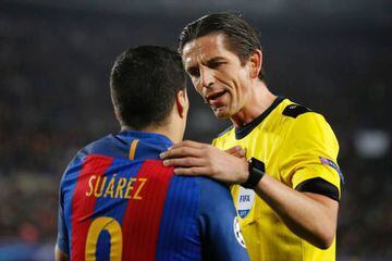 Referee puts hand on shoulder of Barcelona's Uruguayan forward Luis Suarez during the UEFA Champions League match against Paris Saint-Germain FC at the Camp Nou and he stays up.