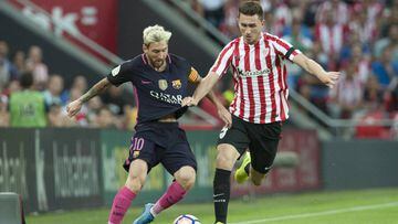 Leo Messi lucha por un bal&oacute;n con Aymeric Laporte durante el partido de Liga Santander entre Athletic de Bilbao y F.C. Barcelona.