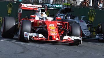 Sebastian Vettel con el Ferrari por delante de Nico Rosberg y su Mercedes.