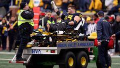 Zak Zinter, #65 of the Michigan Wolverines, acknowledges the crowd as he is carted off the field