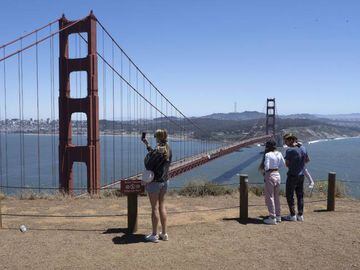 People take photos of the Golden Gate Bridge and the San Francisco skyline.