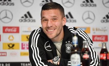 Germany's midfielder Lukas Podolski smiles as he answers to questions during a joint press conference with Germany's head coach Joachim Loew (unseen) in Dortmund, Germany on March 21, 2017, one day ahead of the friendly football match between Germany and 