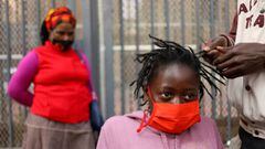 A mother looks on as her daughter is attended to by roadside hairdresser, openly flouting lockdown regulations amid the spread of the coronavirus disease (COVID-19), in Johannesburg, South Africa, June 6, 2020. Picture taken June 6, 2020. REUTERS/Siphiwe 