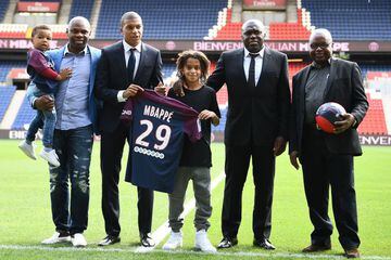 Paris Saint-Germain's new forward Kylian Mbappe (3L) together with father Wilfried Mbappe (2R) and his brother Ethan (3R) and other members of his family pose for a photo during the presentation of his jersey at the Parc des Princes stadium in Paris on Se