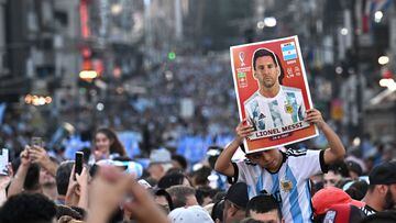 A fan of Argentina holds a poster of football star Lionel Messi while celebrating after Argentina defeated Australia in the Qatar 2022 World Cup round of 16 football match, at 9 de Julio avenue, in Buenos Aires, on December 3, 2022. (Photo by Luis ROBAYO / AFP)