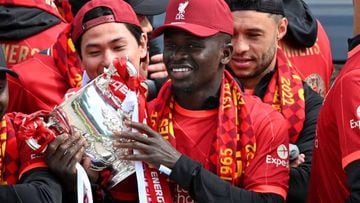 Liverpool's Senegalese striker Sadio Mane celebrates with temmates on an open-top bus during a parade through the streets of Liverpool in north-west England on May 29, 2022, to celebrate winning the 2021-22 League Cup and FA Cup. - Despite the disappointment of losing to real Madrid in the final of the UEAF Champions League, Klopp has called on Liverpool fans to take to the streets of the city on Sunday when they parade the League Cup and FA Cup. (Photo by Oli SCARFF / AFP) (Photo by OLI SCARFF/AFP via Getty Images)