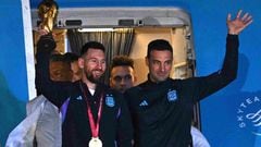 Argentina's captain and forward Lionel Messi (L) holds the FIFA World Cup Trophy alongside Argentina's coach Lionel Scaloni as they step off a plane upon arrival at Ezeiza International Airport after winning the Qatar 2022 World Cup tournament in Ezeiza, Buenos Aires province, Argentina on December 20, 2022. (Photo by Luis ROBAYO / AFP)