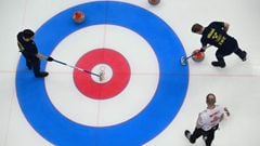 Sweden&#039;s Rasmus Wranaa (top, R) sweeps during the men&#039;s semifinal game of the Beijing 2022 Winter Olympic Games curling competition against Canada at the National Aquatics Centre in Beijing on February 17, 2022. (Photo by Lillian SUWANRUMPHA / A
