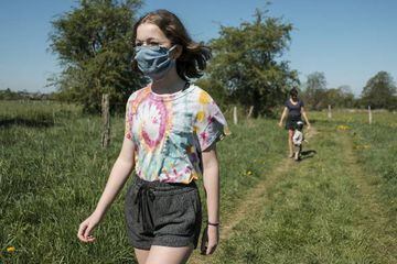 A child wearing a protective face mask walks in the countryside near Harinsart, Belgium, 25 April 2020.
