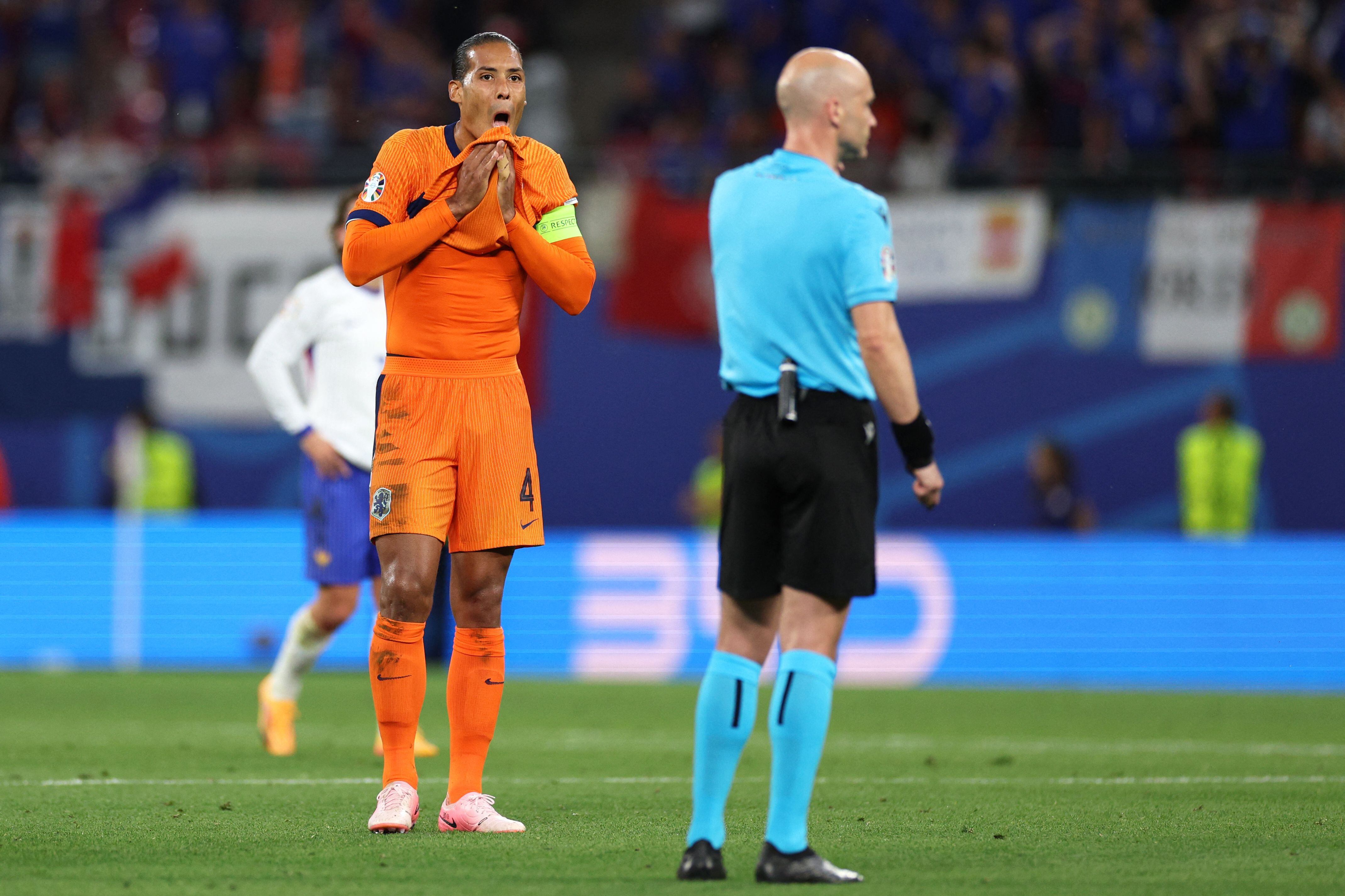 Netherlands' defender #04 Virgil Van Dijk (L) reacts to a VAR check for a team goal during the UEFA Euro 2024 Group D football match between the Netherlands and France at the Leipzig Stadium in Leipzig on June 21, 2024. (Photo by Adrian DENNIS / AFP)