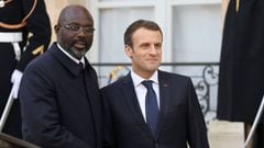 French President Emmanuel Macron (R) and Liberian President George Weah shake hands as they leave the Elysee presidential palace after a lunch on February 21, 2018 in Paris. / AFP PHOTO / LUDOVIC MARIN
