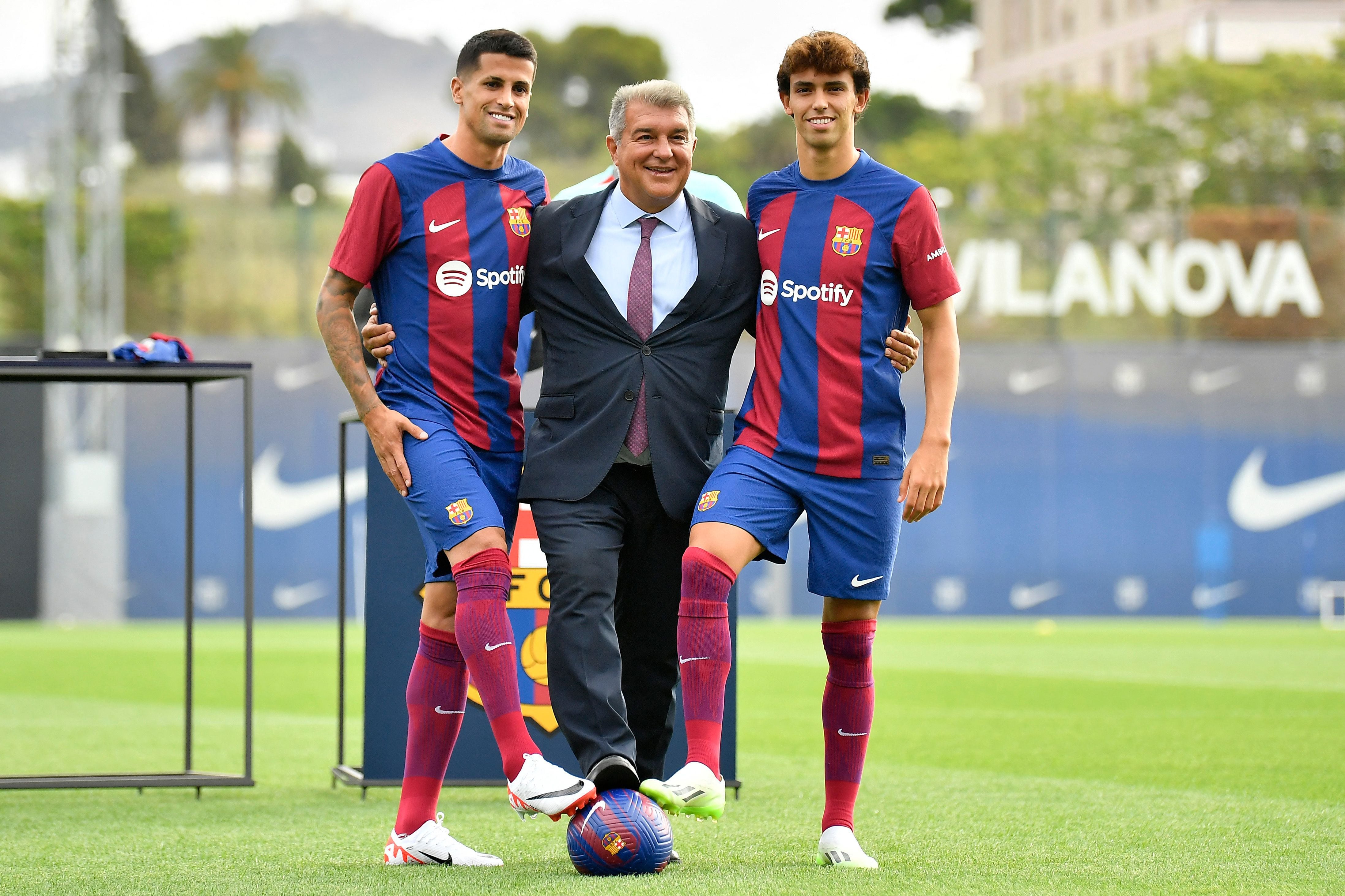 João Félix y João Cancelo con el presidente del Barcelona, Joan Laporta, durante su presentación.