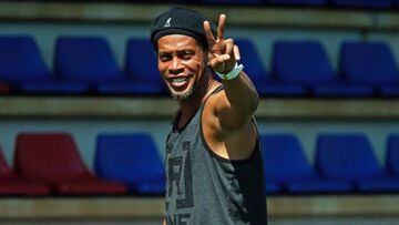 Ronaldinho haciendo la se&ntilde;al de victoria en un campo de f&uacute;tbol vacio