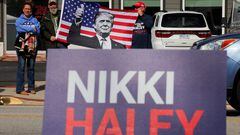 Men hold a U.S. flag with a photo of Donald Trump, as Republican presidential candidate and former U.S. Ambassador to the United Nations Nikki Haley makes a campaign stop ahead of the South Carolina Republican presidential primary election in Moncks Corner, South Carolina, U.S. February 23, 2024. REUTERS/Brian Snyder