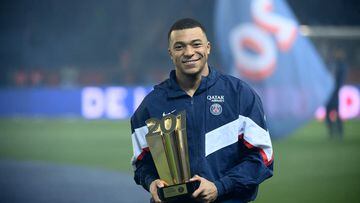 Paris Saint-Germain's French forward Kylian Mbappe poses with a trophy at the end of a ceremony after he became Paris Saint-Germain's all-time top scorer with his 201st goal for the club in their 4-2 win in the French L1 football match against FC Nantes at The Parc des Princes Stadium in Paris on March 4, 2023. (Photo by FRANCK FIFE / AFP)