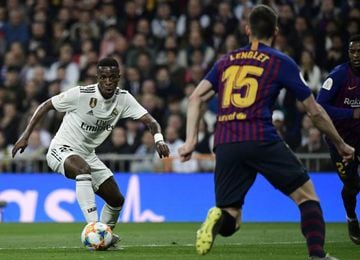 Real Madrid's Brazilian forward Vinicius Junior (L) vies with Barcelona's French defender Clement Lenglet