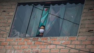 Venezuelan Carlos, 9, peers out the window at the house of the Hernandez family in Villa Maria del Triunfo neighborhood, south of Lima, on June 25, 2020. - The 14 members of the Hernandez family arrived in Peru from Venezuela two years ago, but the coronavirus has put their hopes for a better life in check: The grandfather died and the other 13 are trying to survive the disease. (Photo by ERNESTO BENAVIDES / AFP)