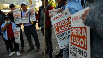 Indigenous people hold signs reading Lasso out!, referring to Ecuadorean President Guillermo Lasso, reproducing the front page of a university weekly newspaper, outside the Central University of Ecuador, where they are taking shelter, in Quito on June 23, 2022, in the framework of indigenous-led protests against the government. - Indigenous Ecuadorans have poured into the capital Quito from across the country in recent days to join protests against high fuel prices and the cost of living. (Photo by Rodrigo BUENDIA / AFP) (Photo by RODRIGO BUENDIA/AFP via Getty Images)