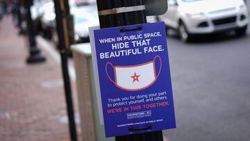 A sign on a lamppost requests people to wear face masks in the Georgetown district of Washington, DC on June 22, 2020. - Washington, DC begins Phase Two of reopening on June 22, 2020 as additional restrictions have been lifted on restaurants, nonessential
