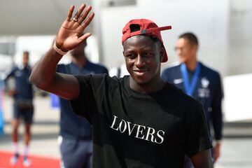France's defender Benjamin Mendy waves as he disembarks from the plane with teammates upon their arrival at the Roissy-Charles de Gaulle airport on the outskirts of Paris, on July 16, 2018 after winning the Russia 2018 World Cup final football match.