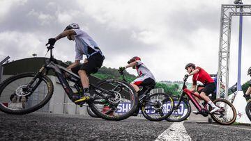 Varios ciclistas con sus E-MTB pasando por la l&iacute;nea de salida de una prueba de la Copa del Mundo UCI 2022. 