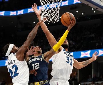 Apr 19, 2022; Memphis, Tennessee, USA; Memphis Grizzlies guard Ja Morant (12) shoots the ball while being guarded by Minnesota Timberwolves guard Patrick Beverley (22) and Minnesota Timberwolves center Karl-Anthony Towns