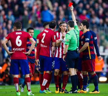 Referee Alberto Undiano Mallenco shows a red card to Filipe Luis (3rd R) after fouling Lionel Messi during the La Liga match between FC Barcelona and Club Atletico de Madrid