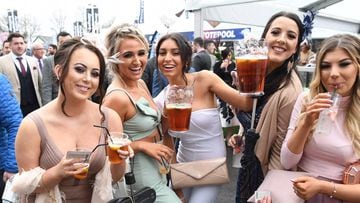 Racegoers pose with glasses during Ladies Day of the Grand National Festival horse race meeting at Aintree Racecourse in Liverpool, northern England on April 13, 2018.  / AFP PHOTO / Paul ELLIS