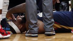 FILE - In this Jan. 26, 2018, file photo, then-New Orleans Pelicans center DeMarcus Cousins lies on the court while being tended to after an injury during the second half of an NBA basketball game against the Houston Rockets in New Orleans. A person with 