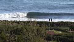 Dos surfistas se&ntilde;alan una ola en Patagonia. 