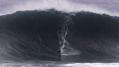 La ola gigante de La Vaca (Cueto, Santander, Cantabria, Espa&ntilde;a), en el Mar Cant&aacute;brico, con un tama&ntilde;o de 8 metros a punto de romper sobre un surfista con un traje de neopreno negro. 
