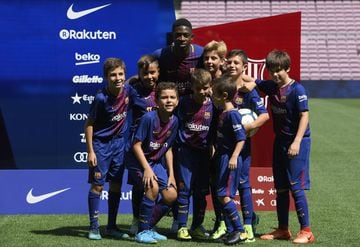 Barcelona's new player Ousmane Dembele poses (C) with young fans at the Camp Nou stadium in Barcelona, during his official presentation by the Catalan football club, on August 28, 2017.