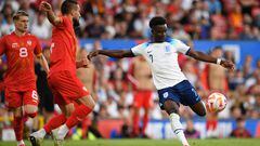 England's midfielder Bukayo Saka (R) shoots past North Macedonia's defender Gjoko Zajkov to score their fourth goal during the UEFA Euro 2024 group C qualification football match between England and North Macedonia at Old Trafford in Manchester, north west England, on June 19, 2023. (Photo by Oli SCARFF / AFP) / NOT FOR MARKETING OR ADVERTISING USE / RESTRICTED TO EDITORIAL USE