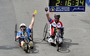 Un superviviente de los atentados de la Maratón de Boston en 2013 y el ciclista Patrick Downes entrando en meta. 