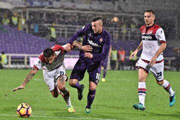 Fiorentina's Federico Bernardeschi and Crotone's Ceccherini battle for the ball amid the rain.