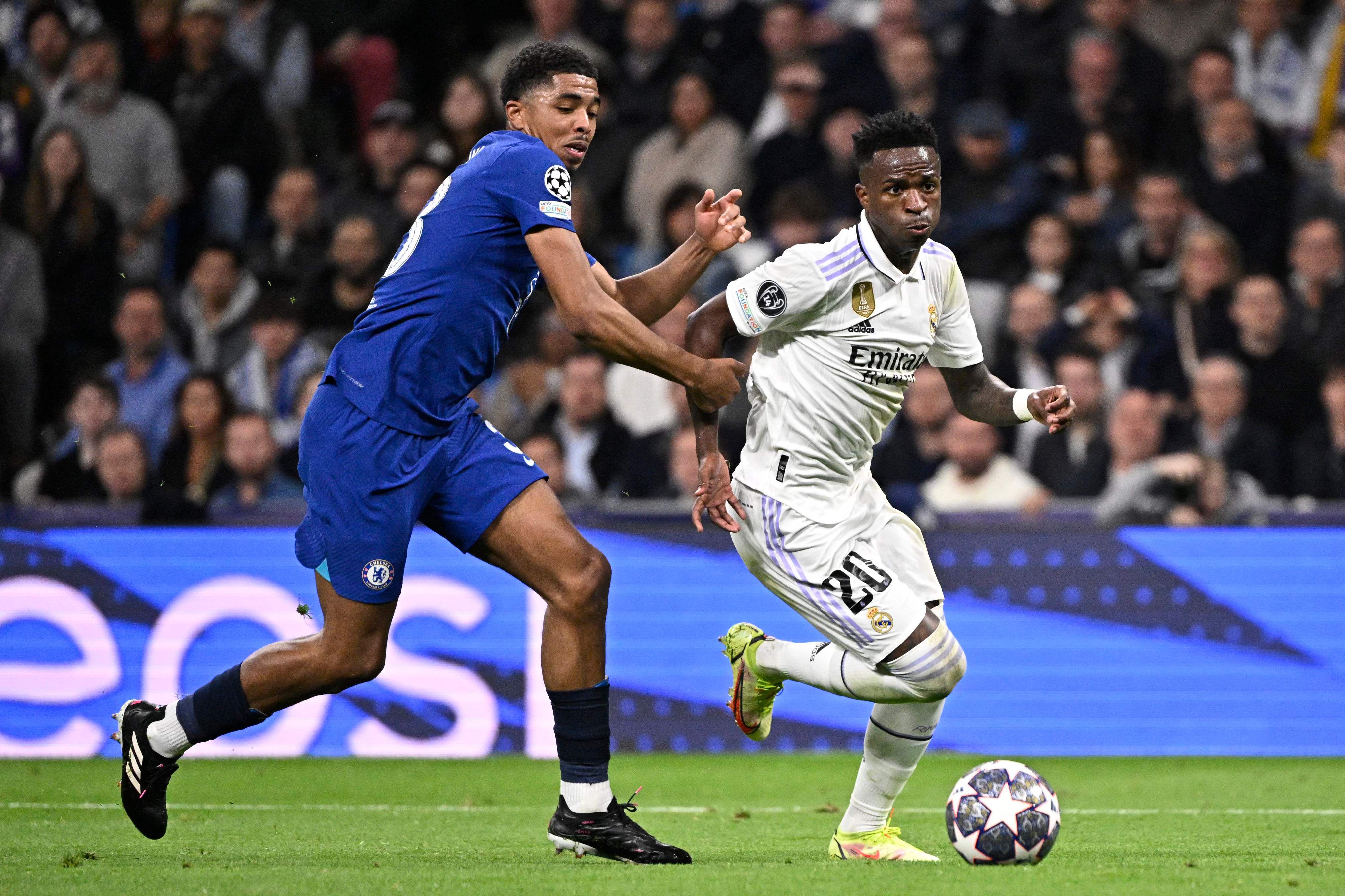 Real Madrid's Brazilian forward Vinicius Junior (R) vies with Chelsea's French defender Wesley Fofana during the UEFA Champions League quarter final first leg football match between Real Madrid CF and Chelsea FC at the Santiago Bernabeu stadium in Madrid on April 12, 2023. (Photo by JAVIER SORIANO / AFP)