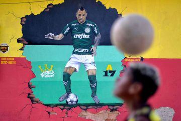 A youngster heads a ball in front of a mural depicting Brazilian Palmeiras footballer Breno Lopes in Belo Horizonte, Minas Gerais state, Brazil, on February 3, 2021. - Breno Lopes went from anonymity to fame in just one header, the same that allows Brazil