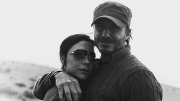 David Beckham abrazando a Victoria Beckham en una foto en blanco y negro tomada en el campo.