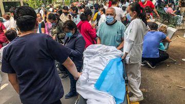 Health workers and patients remain outside the Durango clinic in Mexico City during a quake on June 23, 2020 amid the COVID-19 novel coronavirus pandemic. - A 7.1 magnitude quake was registered Tuesday in the south of Mexico, according to the Mexican National Seismological Service. (Photo by Pedro PARDO / AFP)