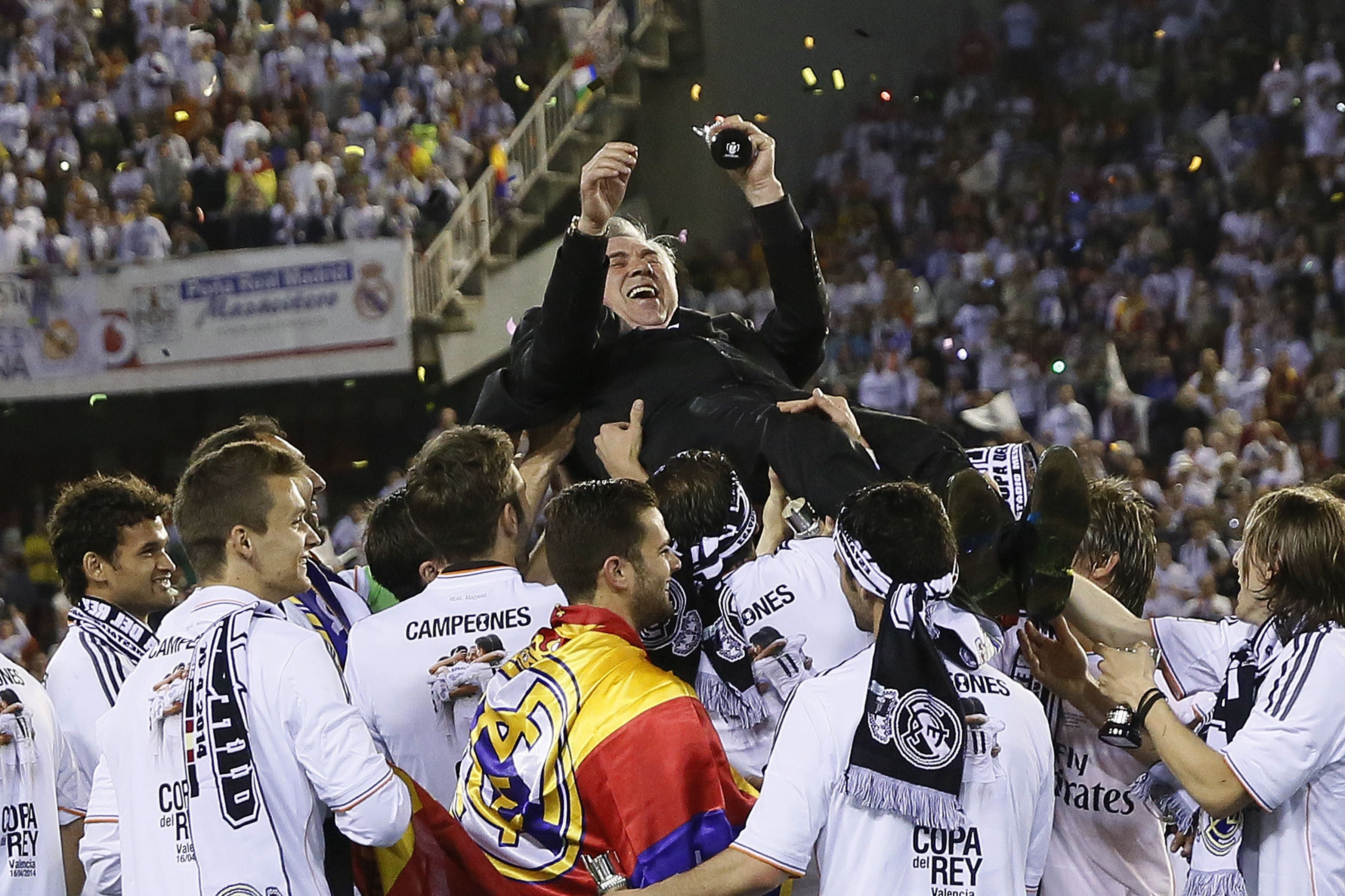 Real Madrid's Italian coach Carlo Ancelotti is tossed by his players after winning the Spanish Copa del Rey (King's Cup) final "Clasico" football match FC Barcelona vs Real Madrid CF at the Mestalla stadium in Valencia on April 16, 2014. Real Madrid won the match 2-1.  AFP PHOTO / CESAR MANSO