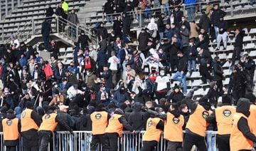 French anti-riot police officers intervene in the stands at half-time during the French Cup round of 64 football match between Paris FC and Olympique Lyonnais (OL) at the Charlety stadium in Paris, on December 17, 2021. -