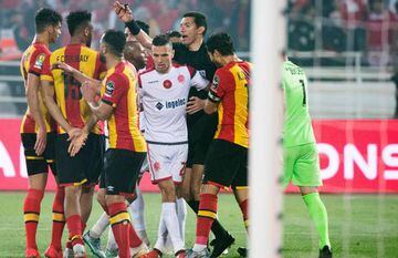 Egyptian referee Ghead Grisha (C) is surrounded by players during the CAF champion league final 2019 1st leg football match between Morocco's Wydad Athletic Club and Tunisia's Esperance sportive de Tunis in Rabat on May 24, 2019. - Grisha has been handed 
