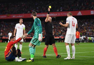Reckless | Refeee Szymon Marciniak shows a yellow card to England's Eric Dier after a needless challenge on Sergio Ramos of Spain.