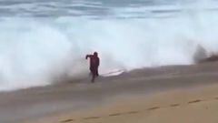 Kelly Slater saliendo del agua en Haw&aacute;i, justo antes de ser tirado al suelo por una ola.