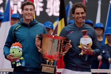 Pablo Carreno Busta y Rafa Nadal, con el trofeo de Pekín.